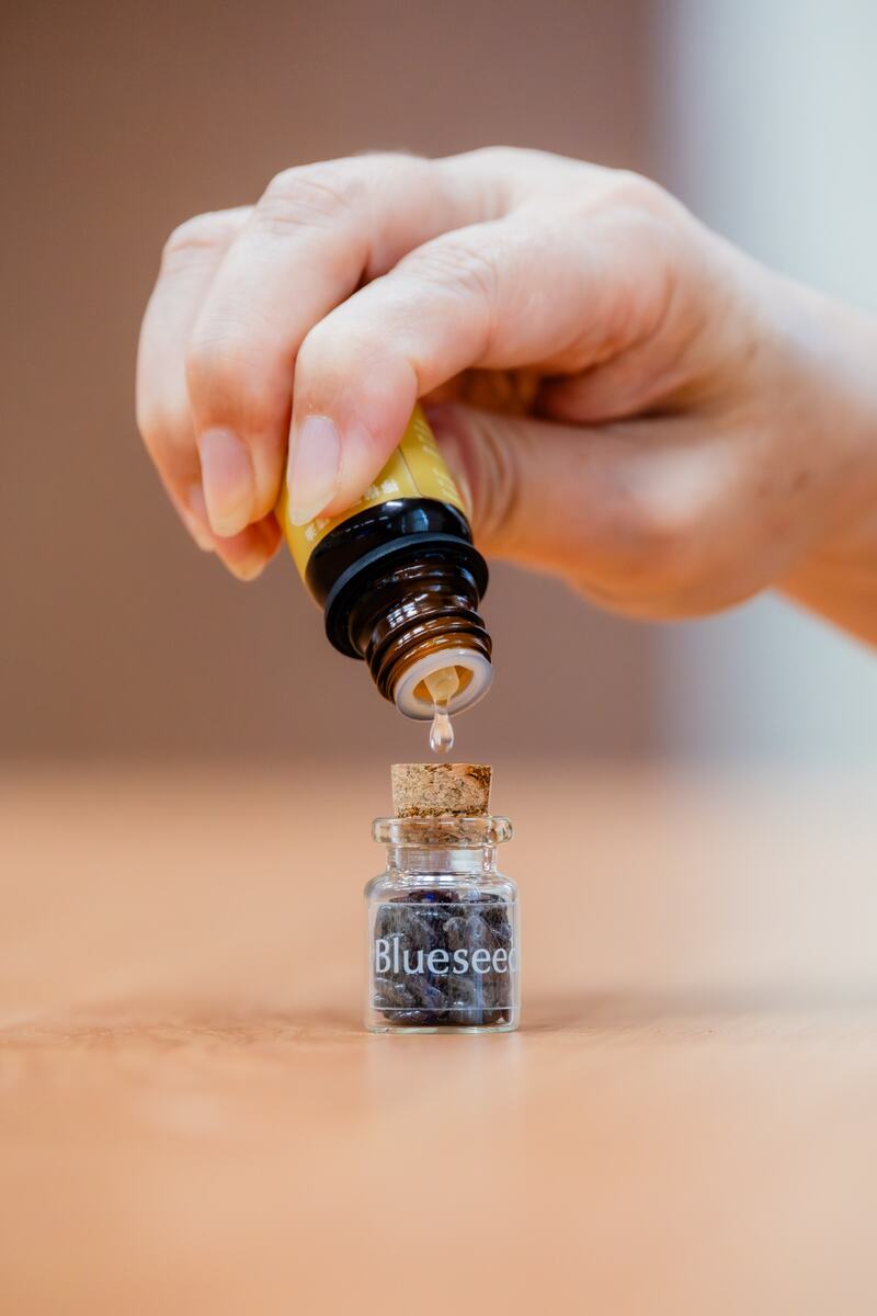 A participant adding botanical aroma oil to a small experience bottle