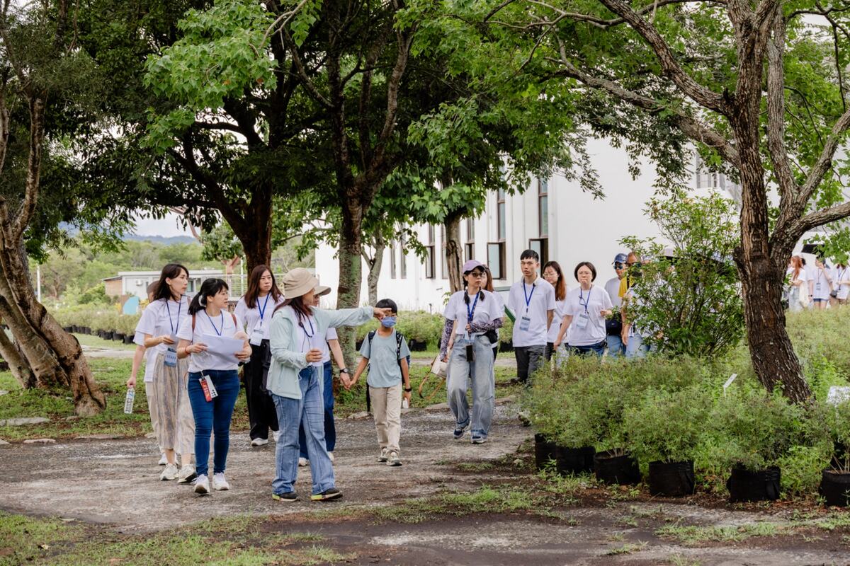 A guide leading visitors through the botanical gardens at Blueseeds Park