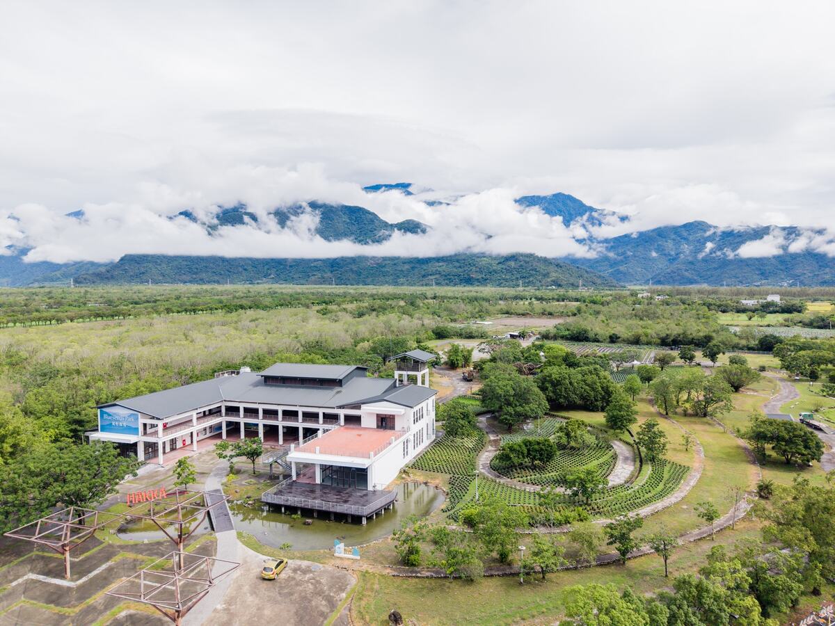 Aerial view of Blueseeds Park and the open fields beneath the mountains